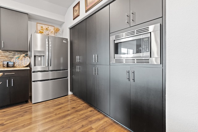 kitchen with decorative backsplash, light hardwood / wood-style floors, and stainless steel appliances