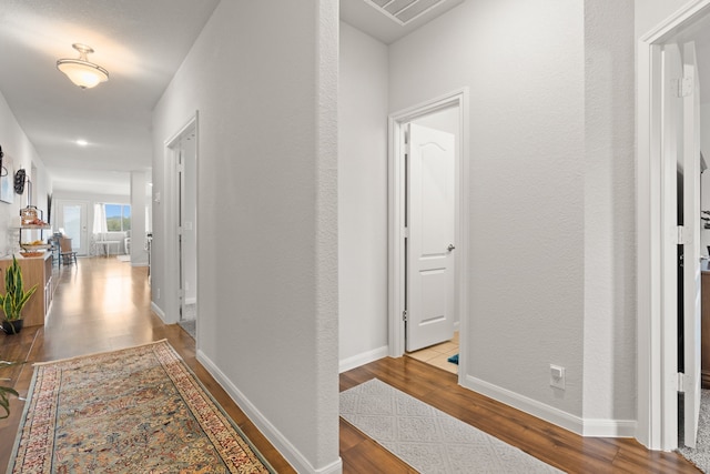 hallway with hardwood / wood-style floors