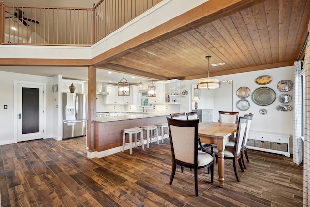 dining room with dark wood-type flooring, a high ceiling, and wooden ceiling