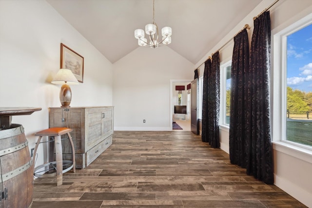 hall with lofted ceiling, dark hardwood / wood-style flooring, and a notable chandelier