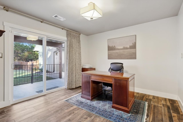 home office with dark hardwood / wood-style flooring