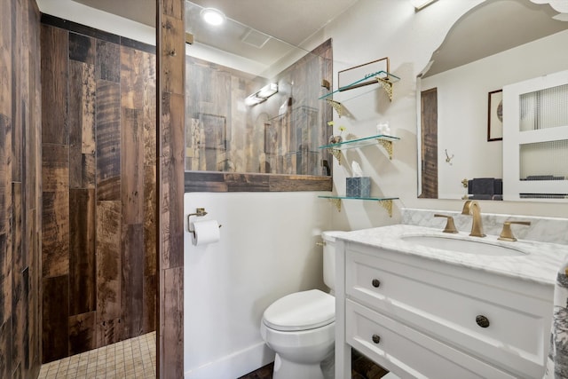 bathroom with vanity, a tile shower, and toilet