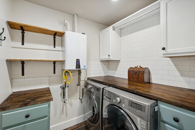 laundry room featuring cabinets, washer and clothes dryer, and water heater