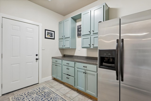 kitchen featuring stainless steel fridge with ice dispenser and light tile patterned flooring