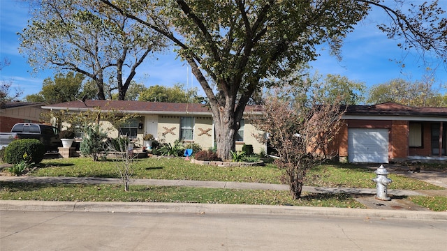 ranch-style house featuring a front yard and a garage