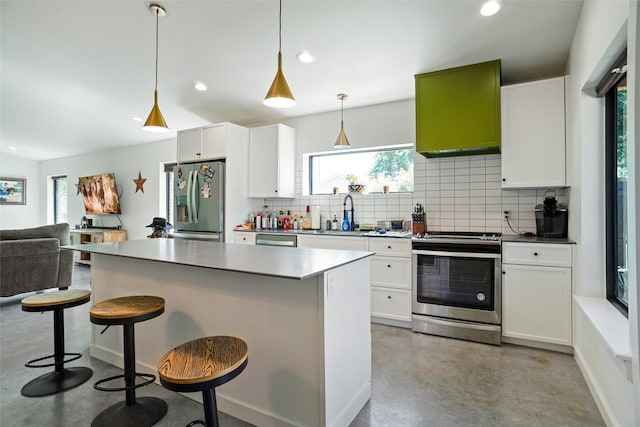 kitchen featuring tasteful backsplash, plenty of natural light, hanging light fixtures, and appliances with stainless steel finishes