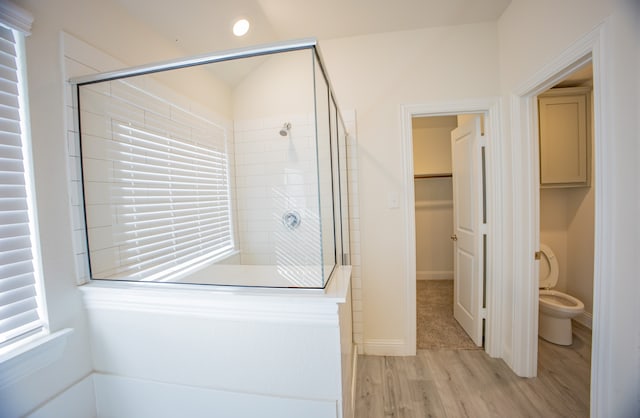 bathroom featuring wood-type flooring, toilet, and an enclosed shower