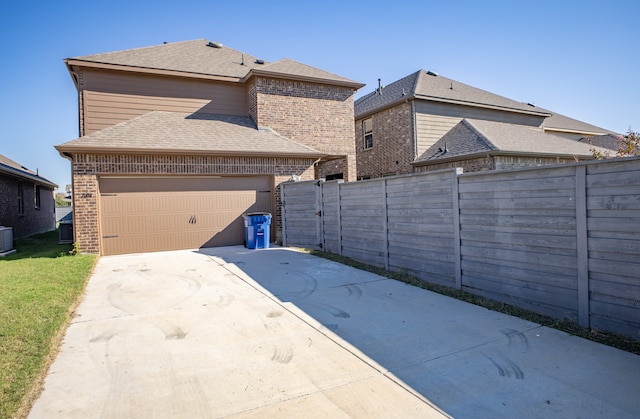 exterior space with a garage and cooling unit