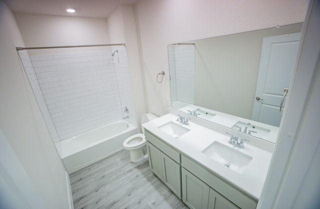 full bathroom featuring vanity, hardwood / wood-style floors, toilet, and tiled shower / bath