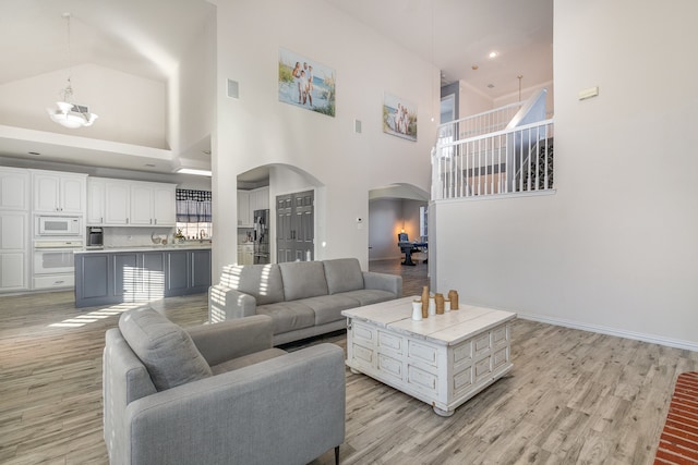 living room featuring a high ceiling and light hardwood / wood-style flooring