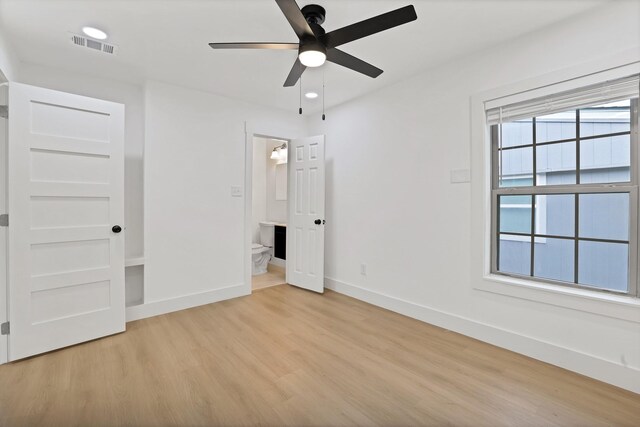 unfurnished bedroom with ceiling fan, light wood-type flooring, and ensuite bath