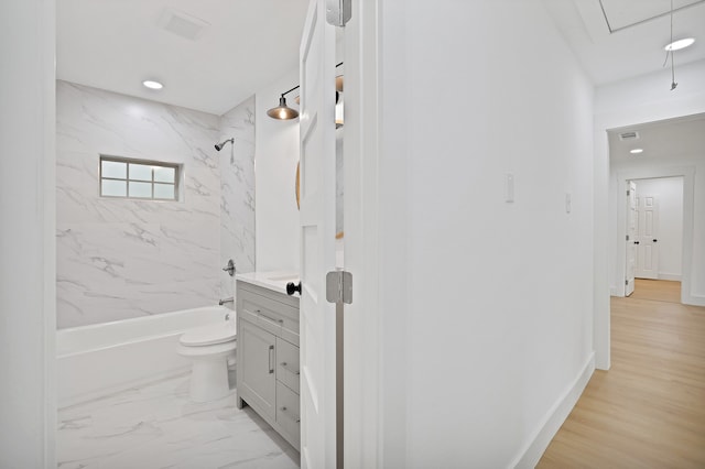 full bathroom featuring tiled shower / bath, toilet, vanity, and hardwood / wood-style flooring