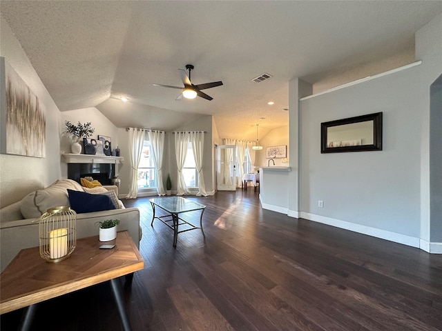 living room with a textured ceiling, dark hardwood / wood-style flooring, ceiling fan, and lofted ceiling