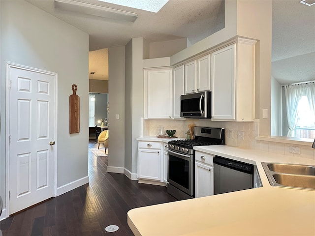 kitchen featuring a textured ceiling, dark hardwood / wood-style flooring, stainless steel appliances, and backsplash