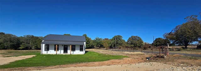 exterior space featuring a rural view and a yard