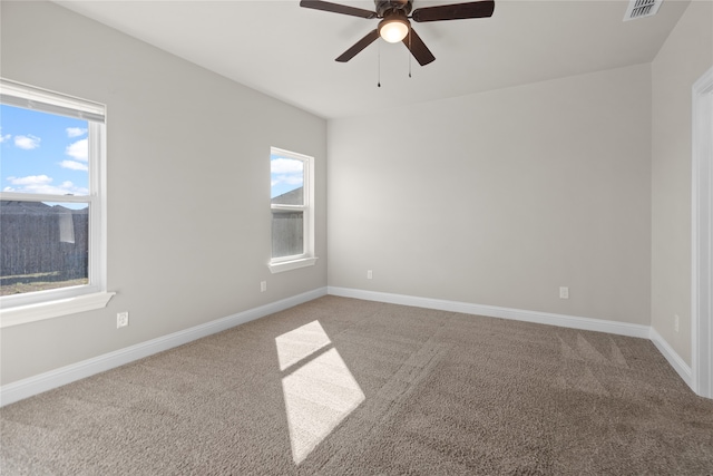 carpeted empty room with ceiling fan and a healthy amount of sunlight