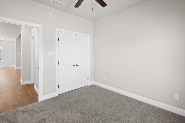 unfurnished bedroom with carpet, a closet, and ceiling fan