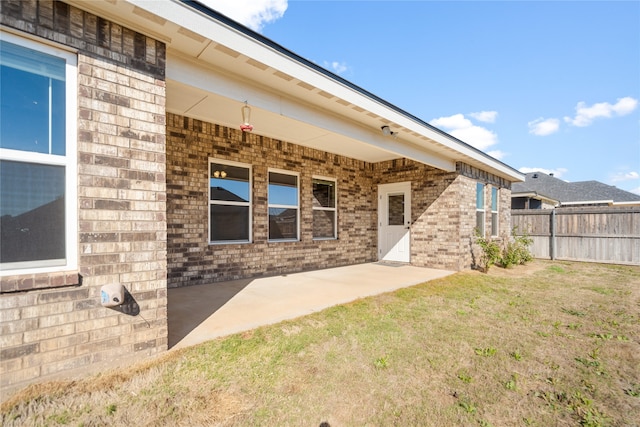 rear view of property featuring a lawn and a patio area