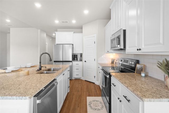 kitchen featuring white cabinetry, sink, a center island with sink, appliances with stainless steel finishes, and hardwood / wood-style flooring