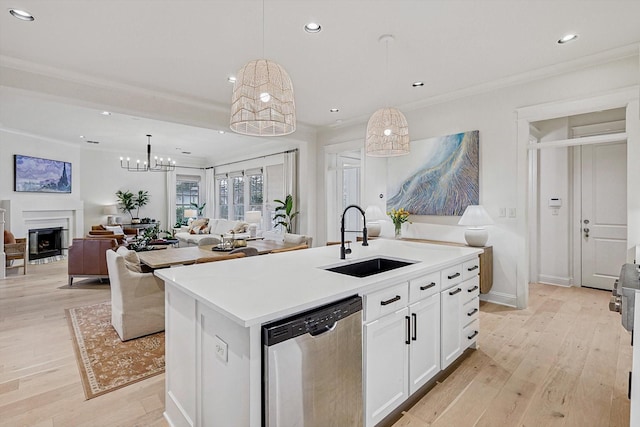 kitchen featuring stainless steel dishwasher, a fireplace, a sink, and light wood-style flooring