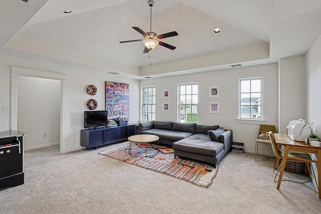 living room featuring a ceiling fan, baseboards, a tray ceiling, and carpet flooring