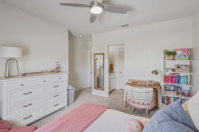 bedroom featuring light carpet, ceiling fan, ensuite bath, and visible vents