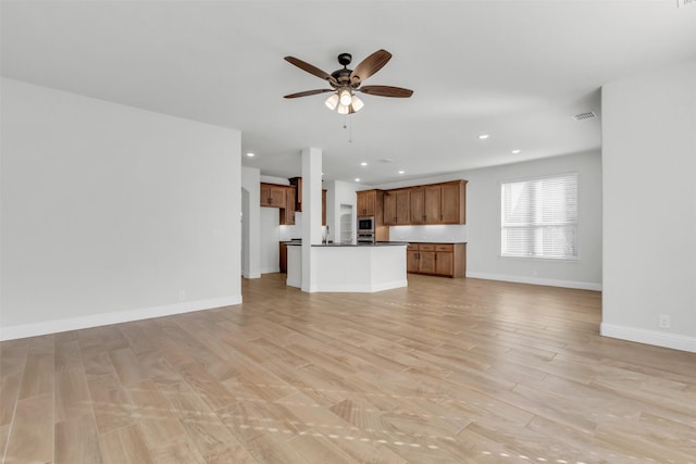 unfurnished living room with ceiling fan and light hardwood / wood-style floors