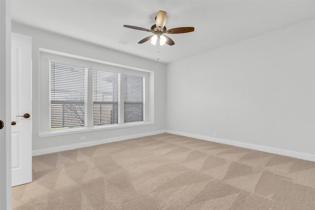 carpeted spare room with ceiling fan