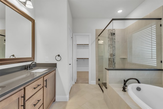 bathroom featuring tile patterned floors, vanity, and shower with separate bathtub