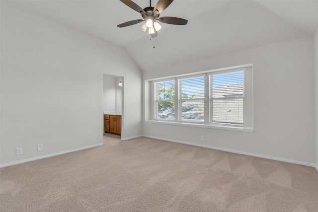 unfurnished bedroom featuring ceiling fan, light colored carpet, lofted ceiling, and connected bathroom