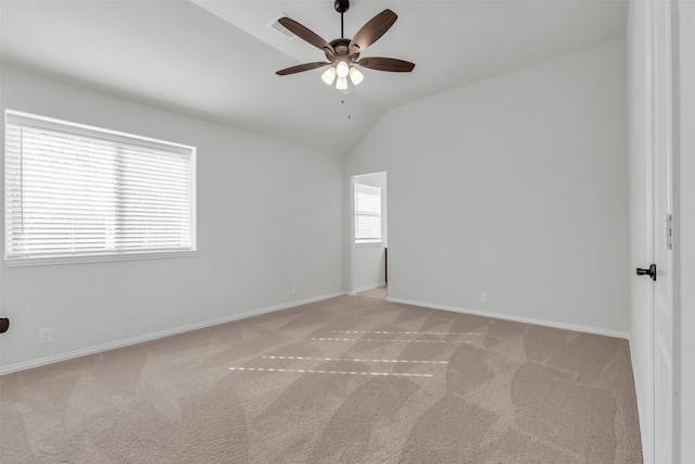 carpeted empty room featuring vaulted ceiling and ceiling fan