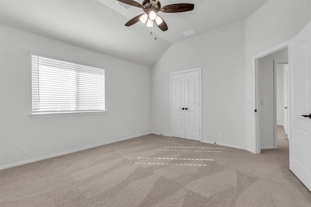 unfurnished bedroom with lofted ceiling, light colored carpet, ceiling fan, and a closet