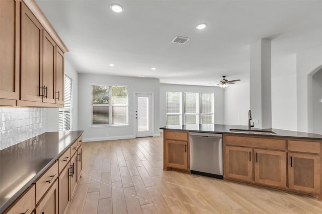 kitchen featuring sink, tasteful backsplash, light wood-type flooring, stainless steel dishwasher, and ceiling fan