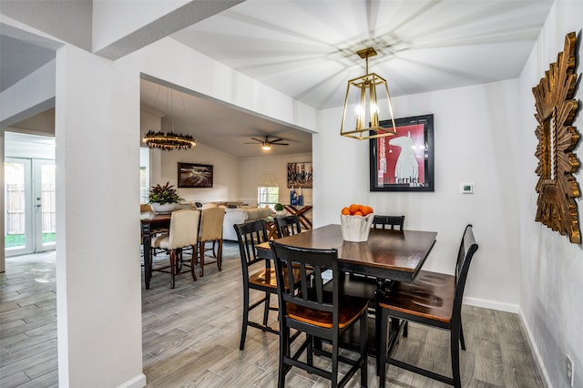 dining space featuring ceiling fan, lofted ceiling, and light wood-type flooring