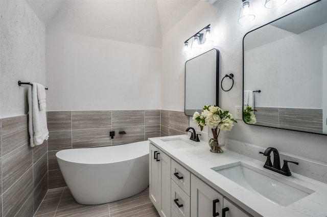 bathroom with vanity, a bathtub, and tile walls