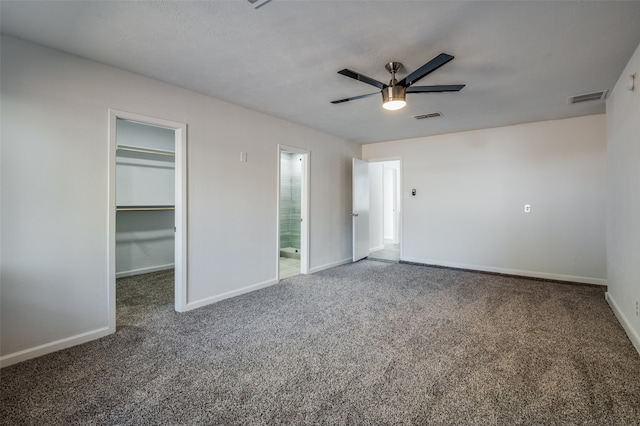 unfurnished bedroom featuring ensuite bathroom, carpet, a spacious closet, ceiling fan, and a closet