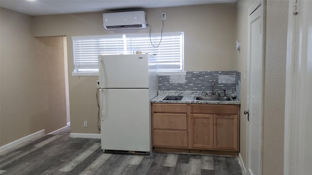 2517 Glencrest Dr, Fort Worth, TX 76119 - kitchen with freestanding refrigerator, a wall unit AC, a sink, and wood finished floors