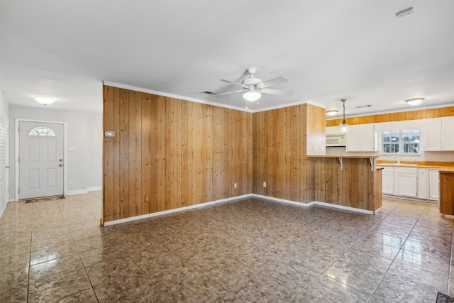 interior space with wooden walls, sink, and ceiling fan