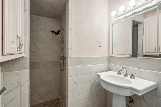 bathroom with a tile shower and tile walls