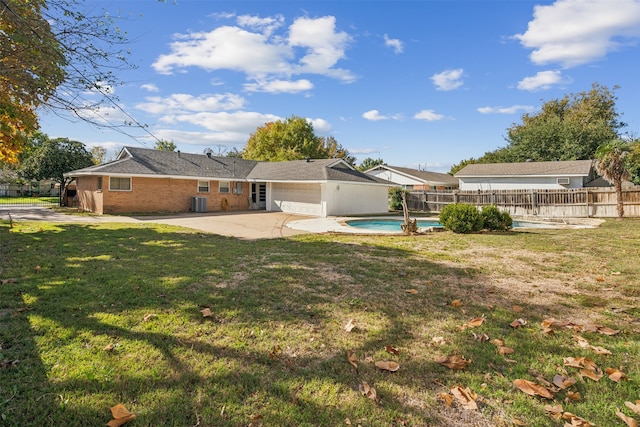 view of yard with a fenced in pool, a garage, and a patio area