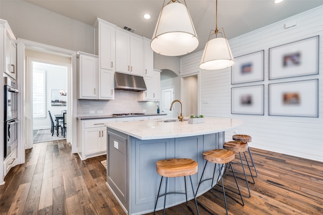 kitchen with white cabinets and wooden walls