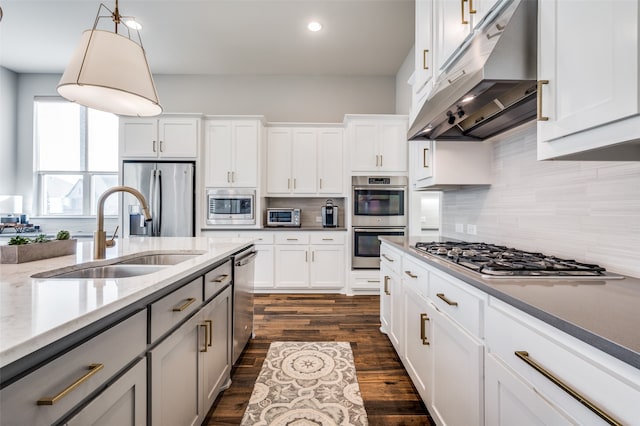 kitchen with pendant lighting, sink, white cabinets, and stainless steel appliances