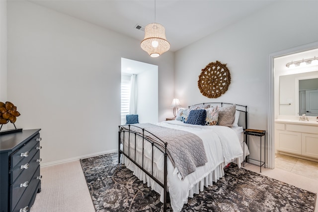 carpeted bedroom featuring sink and connected bathroom