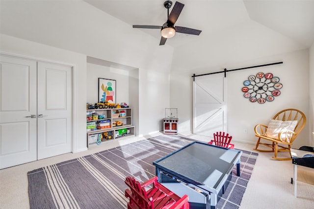 rec room featuring carpet flooring, a barn door, vaulted ceiling, and ceiling fan