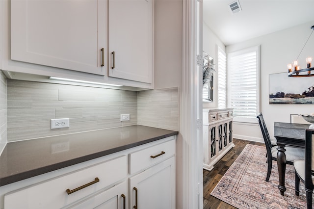 kitchen with an inviting chandelier, tasteful backsplash, dark hardwood / wood-style flooring, decorative light fixtures, and white cabinets