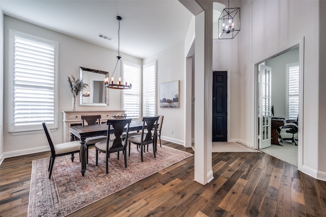 dining room with a notable chandelier and dark wood-type flooring