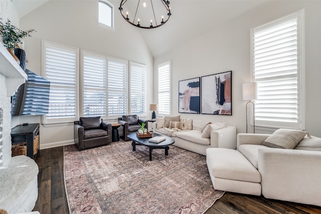 living room featuring dark hardwood / wood-style flooring, high vaulted ceiling, a healthy amount of sunlight, and an inviting chandelier