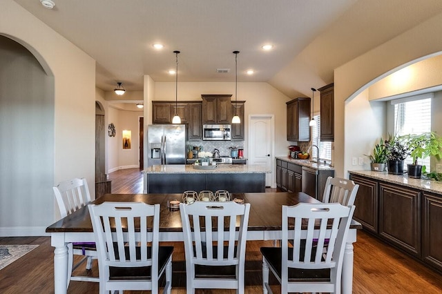 dining space featuring lofted ceiling, sink, and dark hardwood / wood-style floors