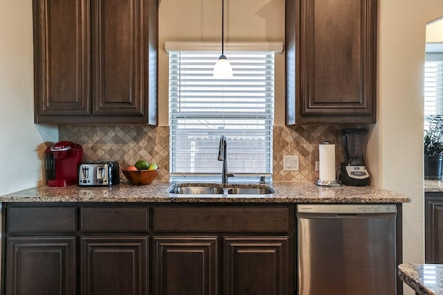 kitchen featuring dark brown cabinetry, sink, light stone counters, hanging light fixtures, and dishwasher