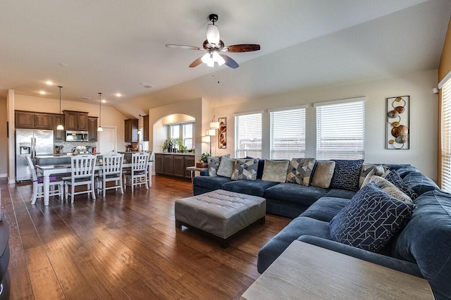 living room featuring ceiling fan, dark wood-type flooring, and vaulted ceiling